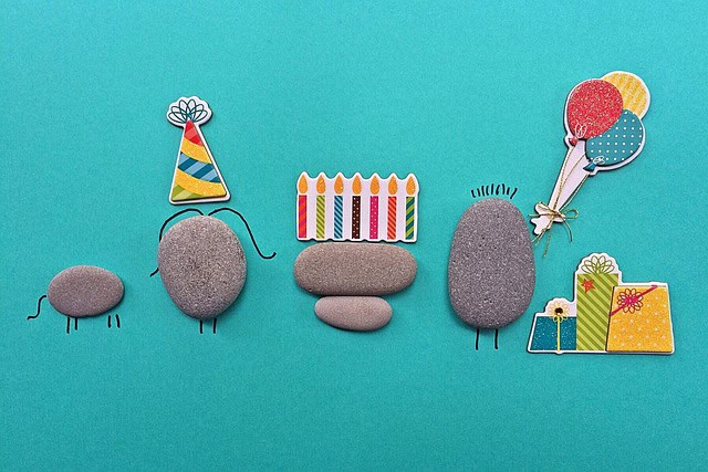 one-hour-art-projects-for-adults-blue-paper-with-pebbles-representing-people-party-hat-balloons.