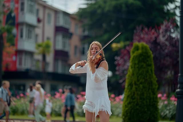 street-performer-woman-white-dress-summer-people-in-background